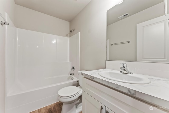 full bathroom featuring vanity, toilet, wood-type flooring, and shower / tub combination