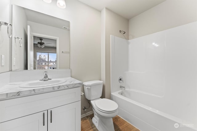 full bathroom with ceiling fan, wood-type flooring,  shower combination, toilet, and vanity