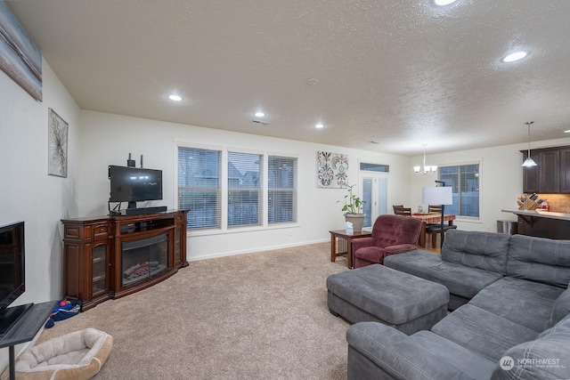 living room with carpet flooring, a chandelier, and a textured ceiling