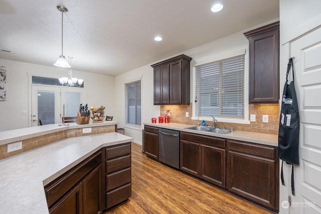4719 Badger St, Moses Lake, WA 98837 - kitchen with stainless steel dishwasher, light wood-style flooring, light countertops, dark brown cabinetry, and decorative light fixtures
