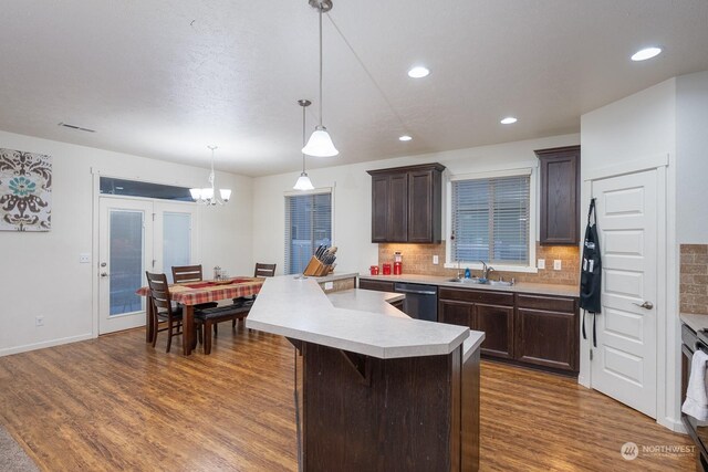 4719 Badger St, Moses Lake, WA 98837 - kitchen with dishwasher, dark brown cabinetry, light countertops, dark wood-style floors, and backsplash