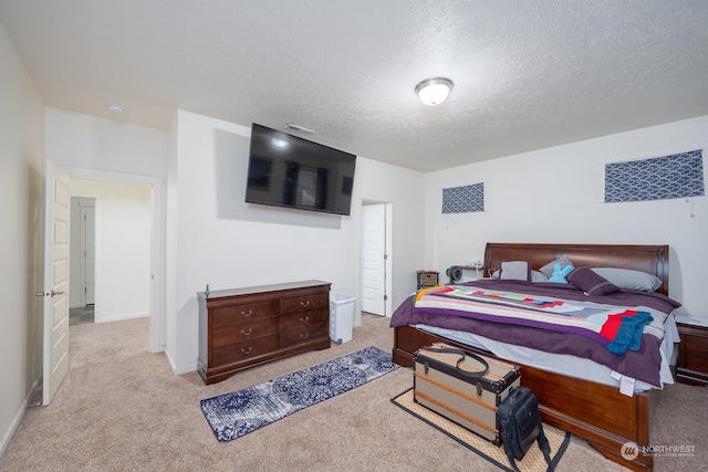 bedroom with a textured ceiling and light colored carpet