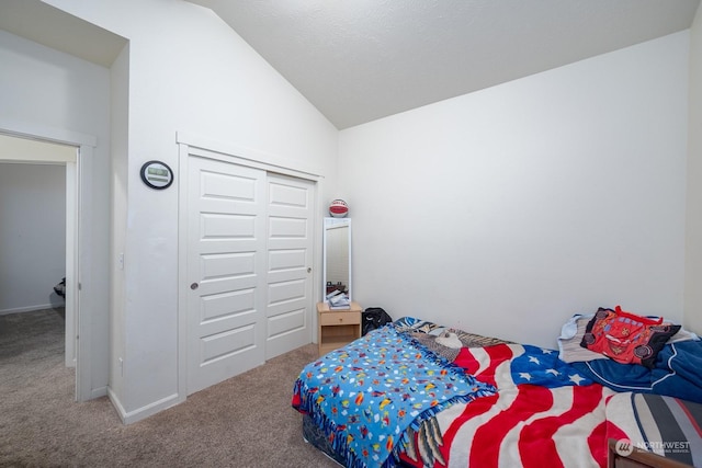 carpeted bedroom with a closet and lofted ceiling