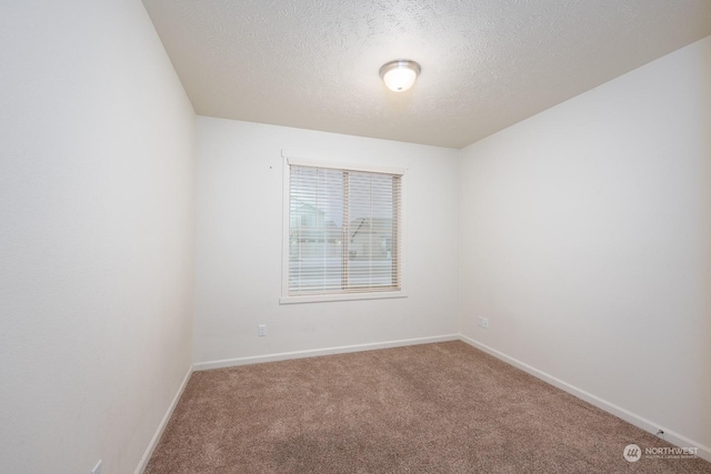 carpeted spare room with a textured ceiling