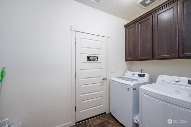 clothes washing area featuring cabinets and washing machine and clothes dryer