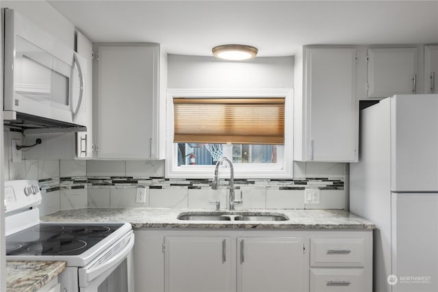 kitchen with tasteful backsplash, white cabinetry, sink, and white appliances