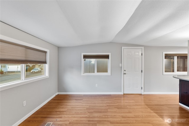 interior space featuring light hardwood / wood-style floors and vaulted ceiling