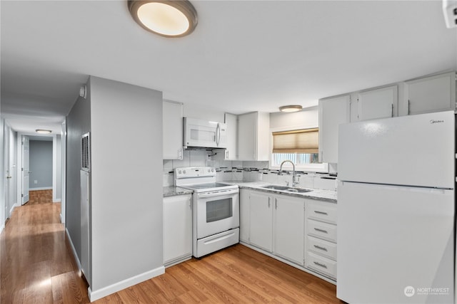 kitchen featuring white cabinetry, sink, backsplash, light hardwood / wood-style floors, and white appliances