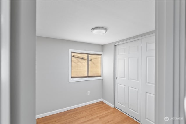 unfurnished bedroom with wood-type flooring and a closet