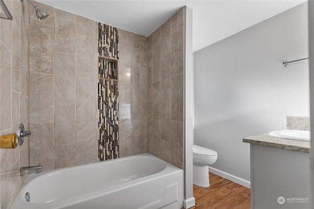 full bathroom with hardwood / wood-style floors, vanity, toilet, and tiled shower / bath combo