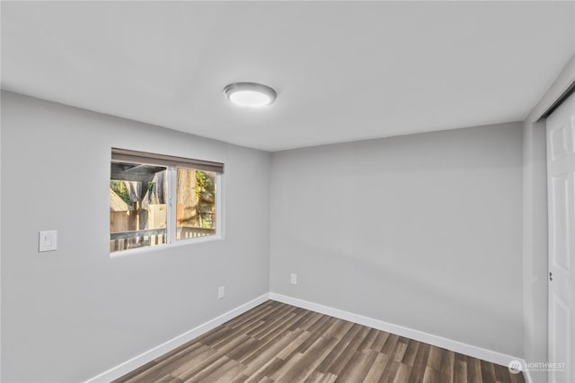 spare room with dark wood-type flooring