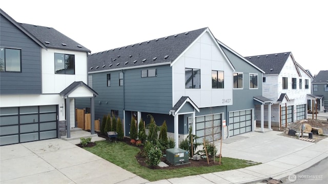 view of front of property with a garage, driveway, and a shingled roof