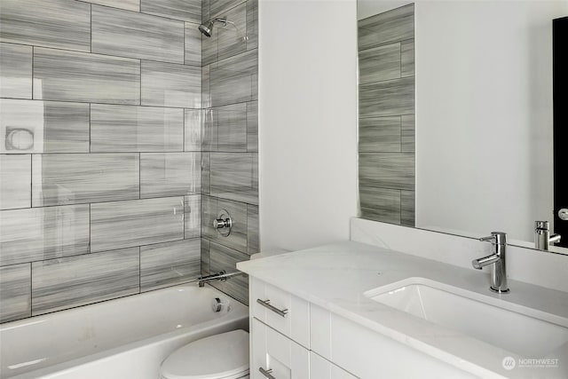 full bathroom featuring toilet, vanity, and tiled shower / bath