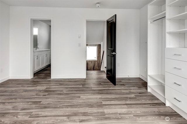 unfurnished bedroom featuring dark wood-type flooring and ensuite bath