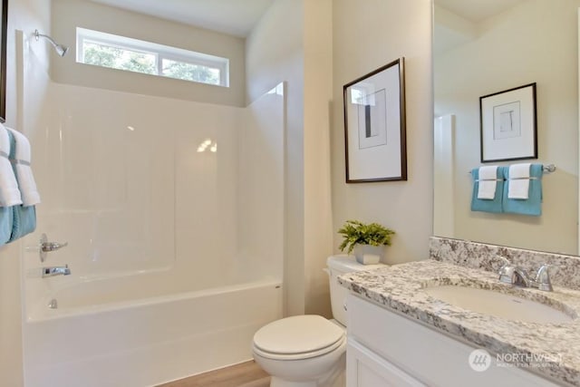 full bathroom with hardwood / wood-style floors, vanity, toilet, and shower / bathing tub combination