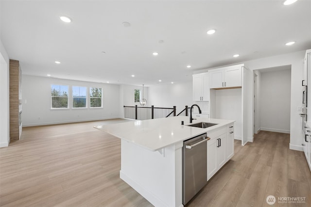 kitchen featuring dishwasher, light wood-style flooring, plenty of natural light, and a sink