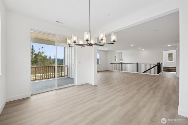 unfurnished dining area featuring visible vents, baseboards, light wood-style floors, and a chandelier