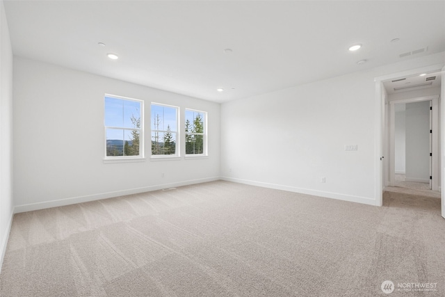 empty room featuring light carpet, visible vents, recessed lighting, and baseboards