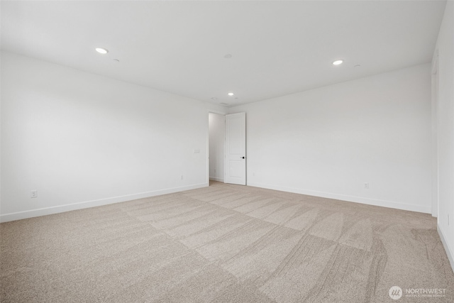 unfurnished room with recessed lighting, baseboards, and light carpet