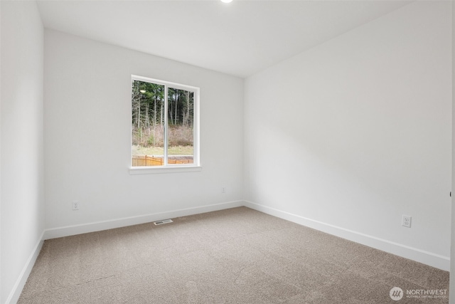 carpeted empty room featuring visible vents and baseboards