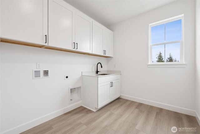 washroom with light wood-type flooring, hookup for a washing machine, cabinet space, hookup for an electric dryer, and a sink