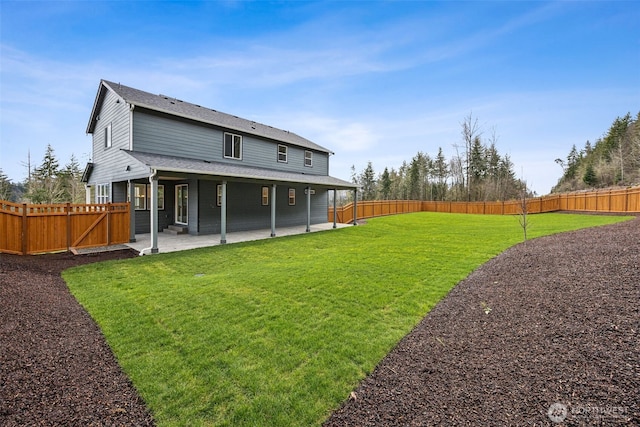 back of property with a yard, a patio area, and a fenced backyard