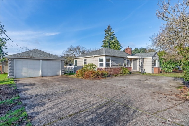 single story home featuring a garage and an outbuilding