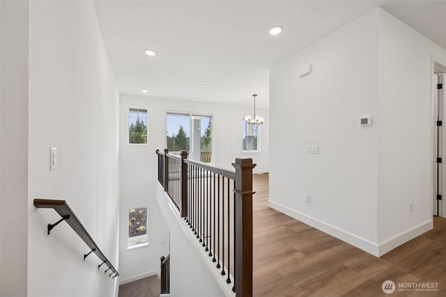 corridor featuring an upstairs landing, recessed lighting, baseboards, and wood finished floors