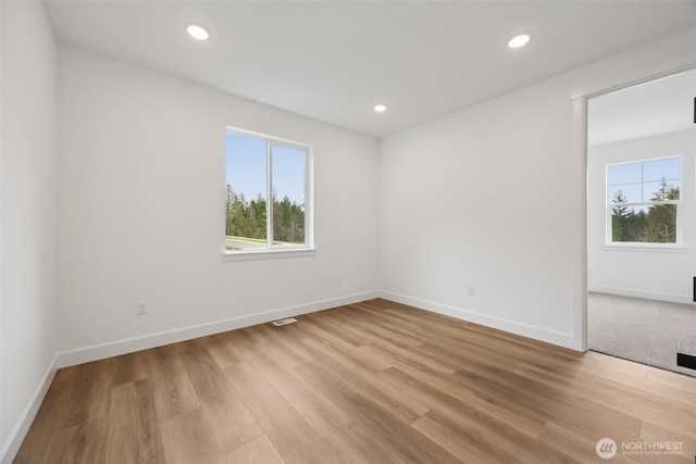 spare room with recessed lighting, visible vents, baseboards, and light wood finished floors