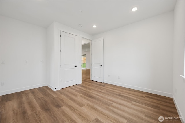 unfurnished room featuring recessed lighting, baseboards, and light wood finished floors