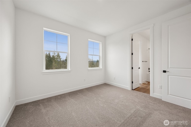 unfurnished bedroom featuring carpet flooring, ensuite bath, and baseboards