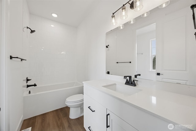 full bathroom with toilet,  shower combination, wood finished floors, and vanity