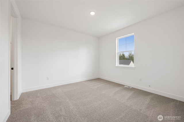 carpeted empty room with visible vents and baseboards