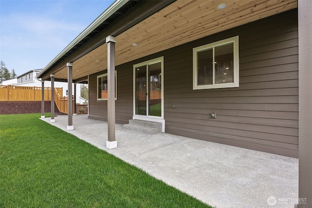 exterior space featuring a lawn, a patio, and fence