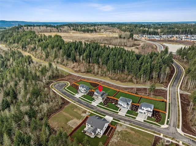 drone / aerial view featuring a wooded view