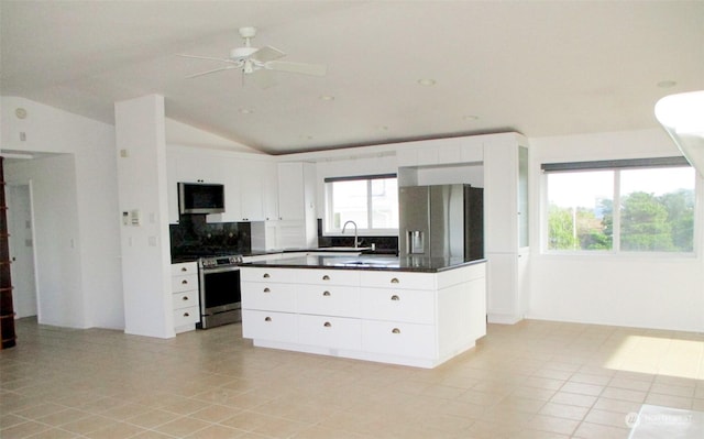 kitchen with decorative backsplash, stainless steel appliances, vaulted ceiling, and a wealth of natural light
