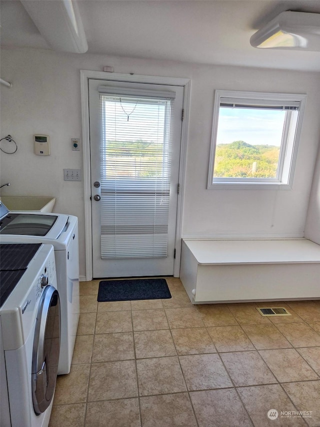 washroom with light tile patterned floors and washing machine and dryer