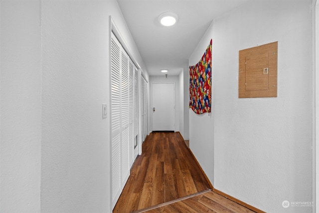 hallway with dark wood-type flooring and electric panel