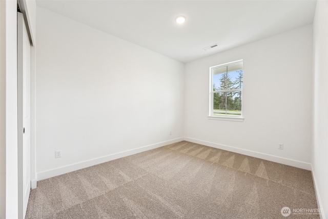 carpeted spare room with baseboards and visible vents