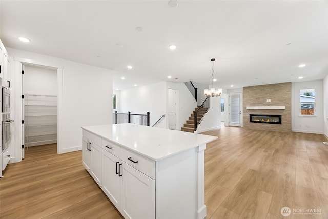 kitchen featuring light wood-style flooring, recessed lighting, white cabinets, and a kitchen island