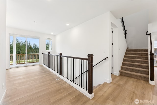 hall with recessed lighting, light wood-style floors, and baseboards