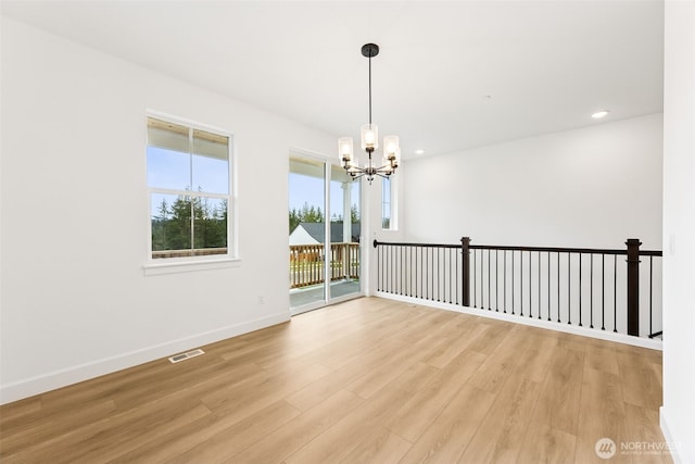 unfurnished room with visible vents, baseboards, recessed lighting, light wood-style floors, and a notable chandelier