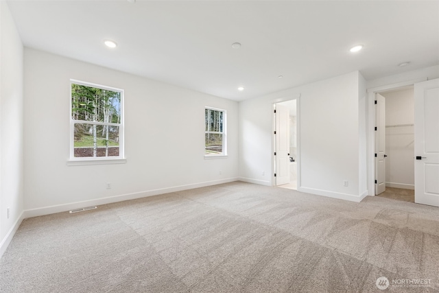 spare room with light carpet, visible vents, recessed lighting, and baseboards