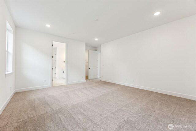 unfurnished bedroom with recessed lighting, light colored carpet, baseboards, and connected bathroom