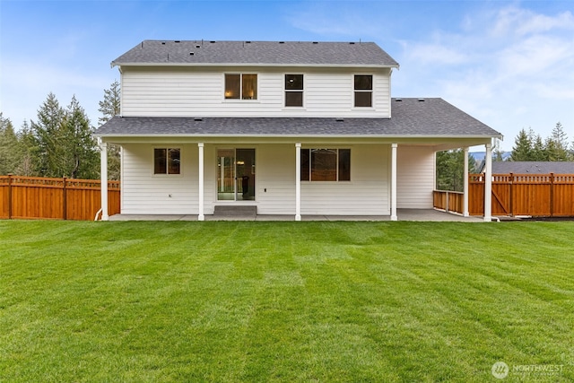 rear view of property featuring a yard, a patio area, and fence