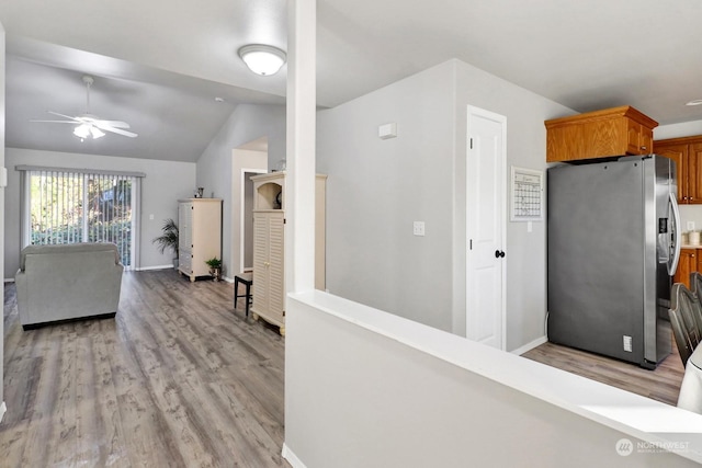 kitchen featuring lofted ceiling, light hardwood / wood-style floors, stainless steel fridge with ice dispenser, and ceiling fan