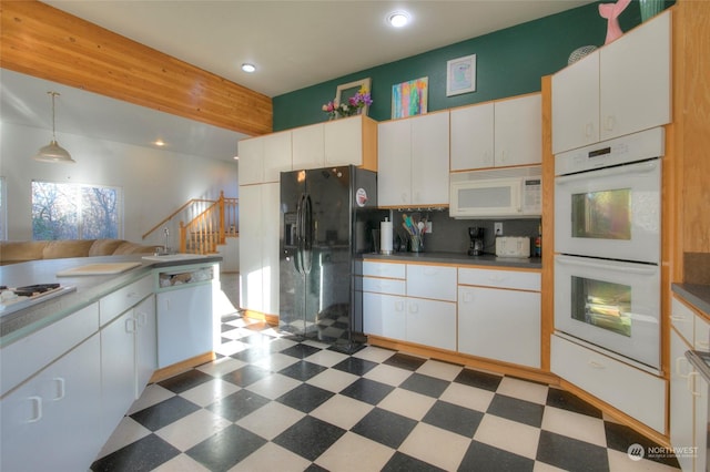 kitchen with sink, white cabinets, pendant lighting, and white appliances