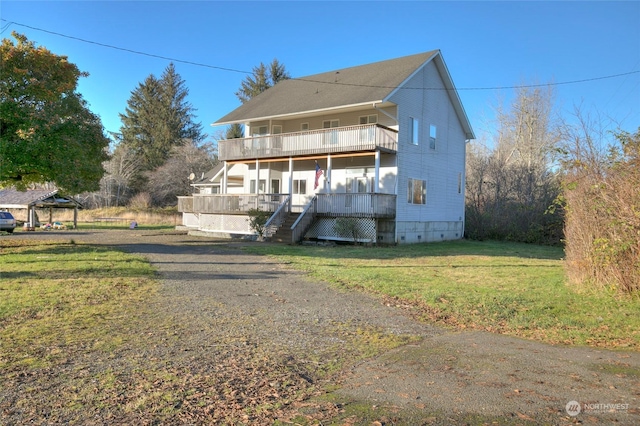 view of front of house featuring covered porch, a gazebo, a balcony, and a front lawn