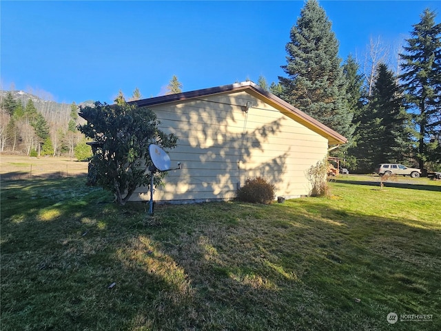 view of side of property with a lawn and a mountain view