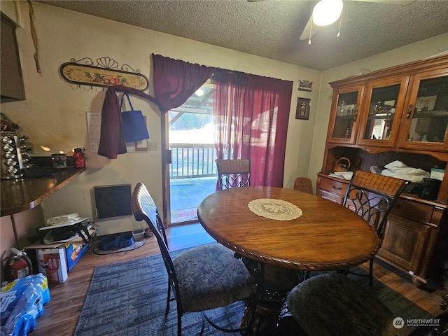 dining room with a textured ceiling, dark hardwood / wood-style floors, and ceiling fan